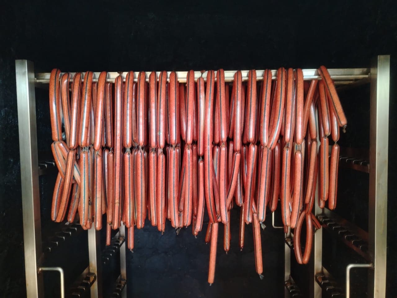 Beef sausages hanging in the LAMI smokehouse